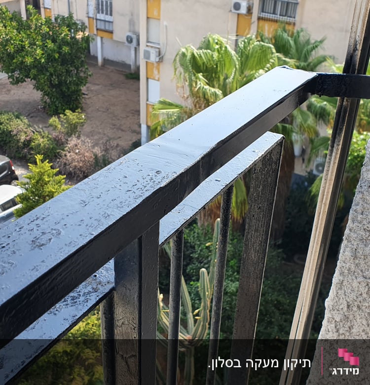 מעקה מתכת שחור עם טיפות מים